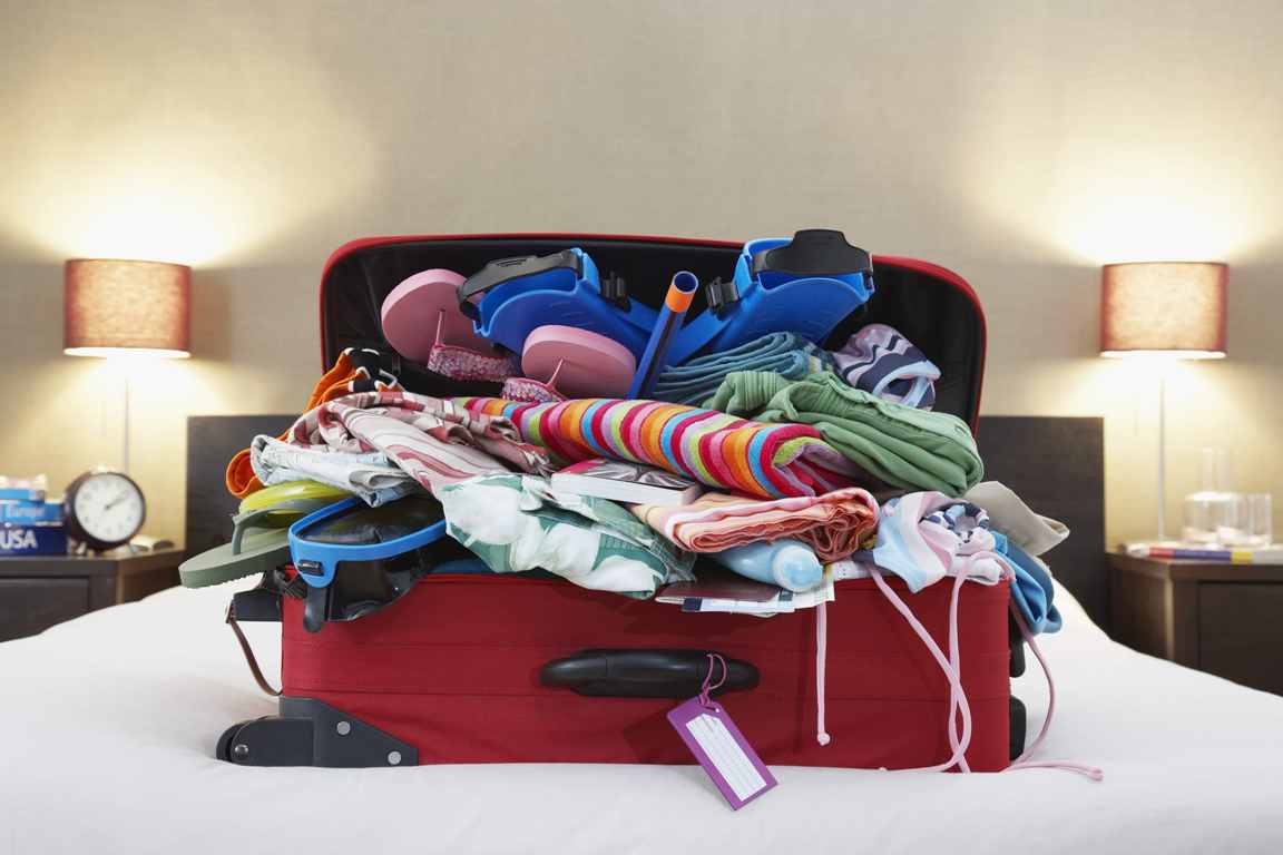 Zu voll gepackter Koffer Koffer voller Kleidungsstücke