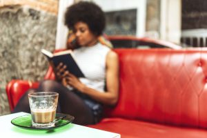 frau mit buch und kaffee