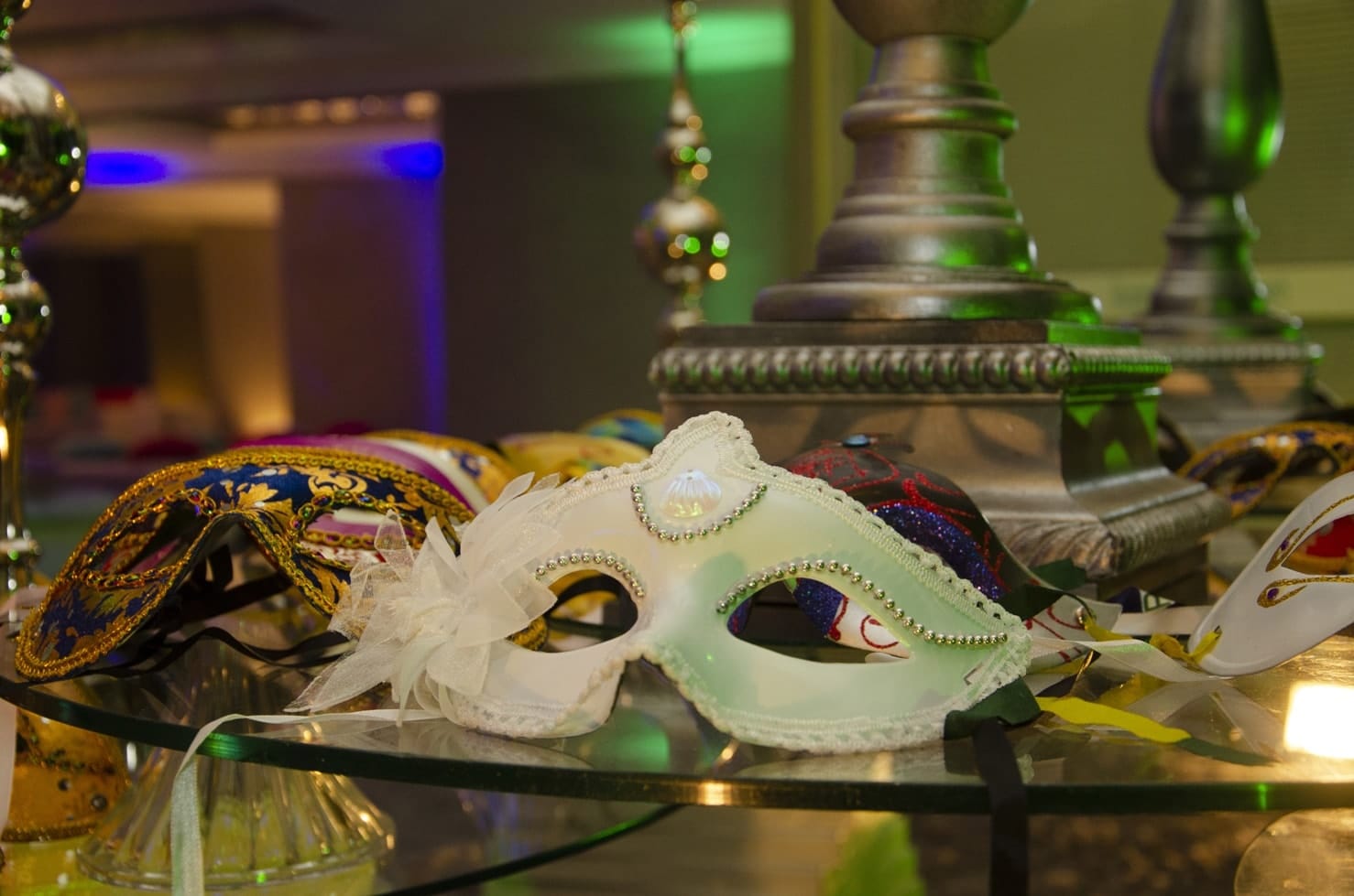 Masken beim Maskenball auf einem Glastisch