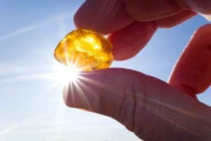 Hand hält Bernstein gegen die Sonne