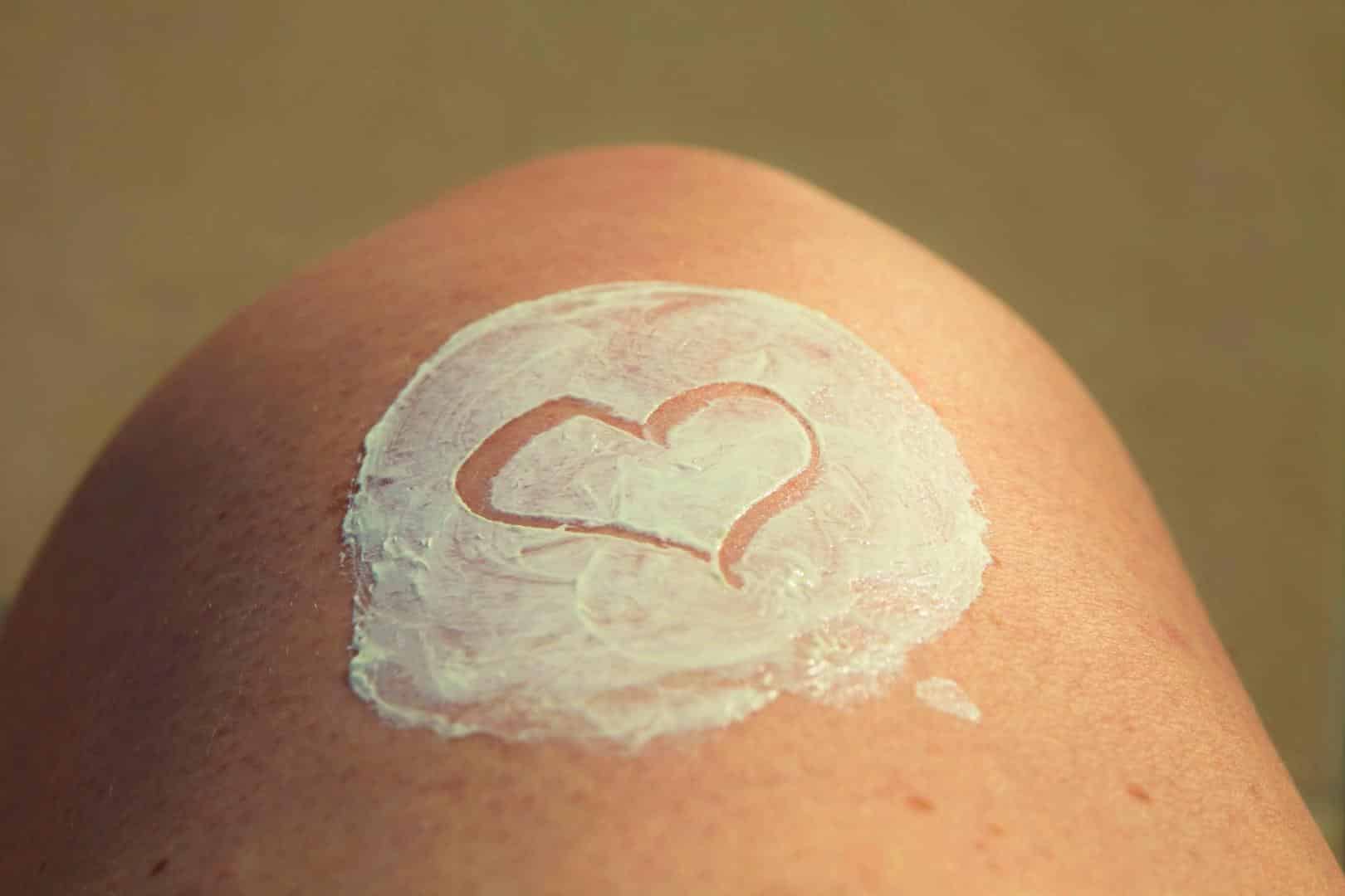 Sonnenschutz Sonnencreme auf einem Bein
