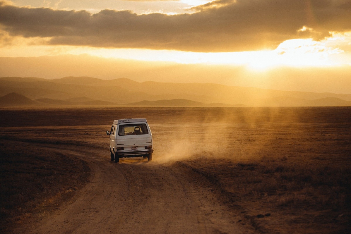 VW-Bus auf einer staubigen Straße - Urlaub mit dem Wohnmobil