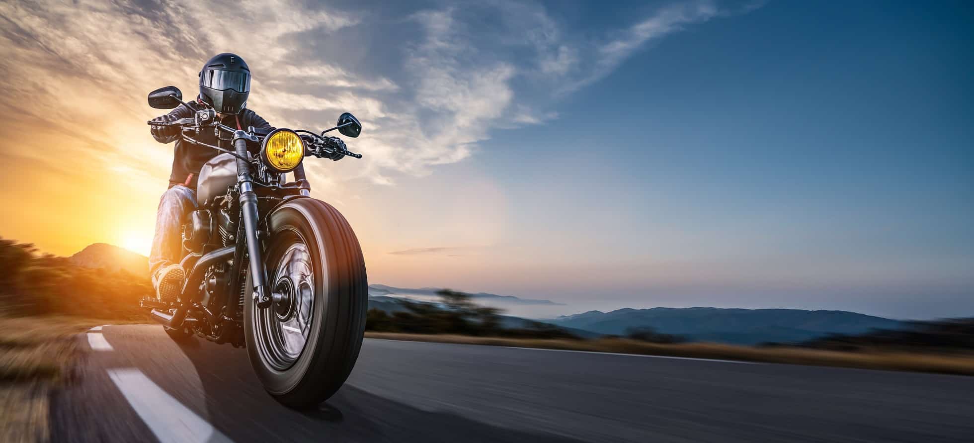 Motorradfahrer auf Landstraße im Abendlicht - Motorrad-Touren in Deutschland