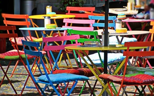 Bunte Tische und Stühle Bunte Gartenstühle und Tische auf Caféterrasse