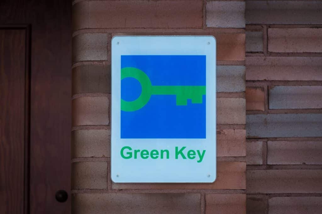 Pärnu, Estonia – February 24, 2023: Green Key certificate sign on hotel wall. Green Key is a voluntary eco-label certified to hotels and other establishments in the world. Green Key Label für Nachhaltige Übernachtungsmöglichkeiten