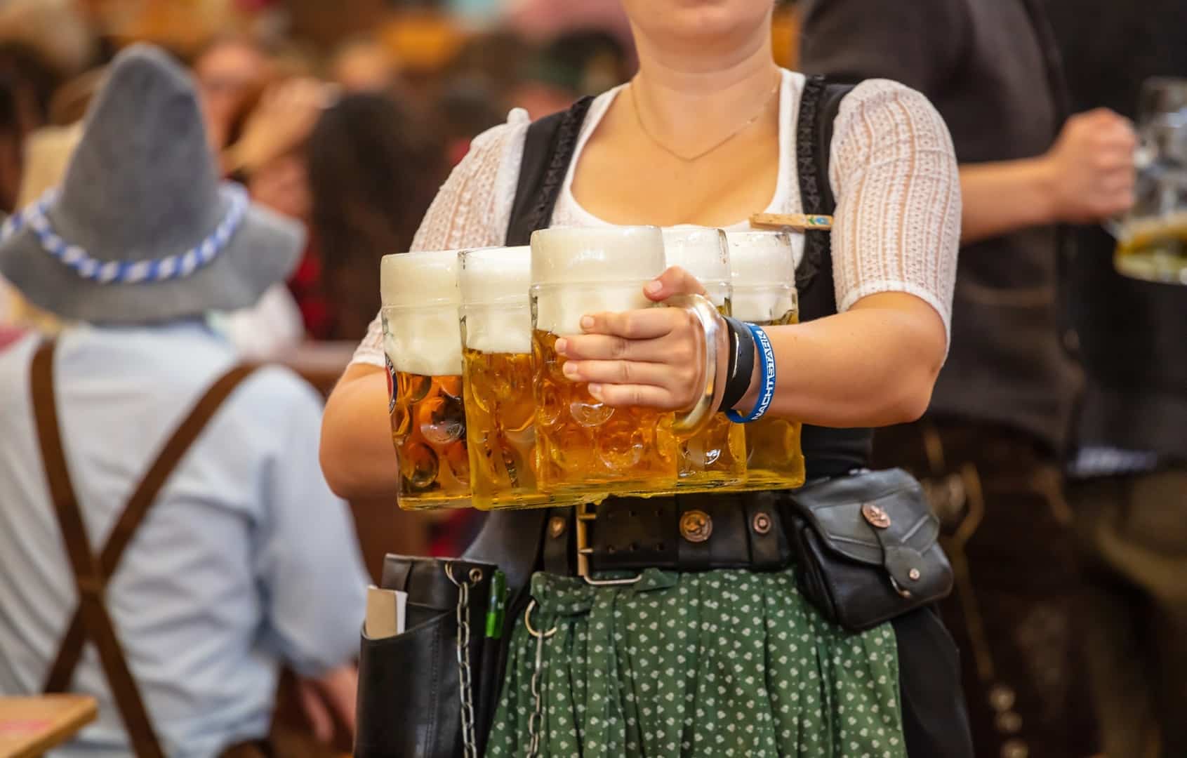 Oktoberfest, Munich, Germany. Waiter with traditional costume holding beers Kellnerin auf dem Oktoberfest in München mit Bierkrügen