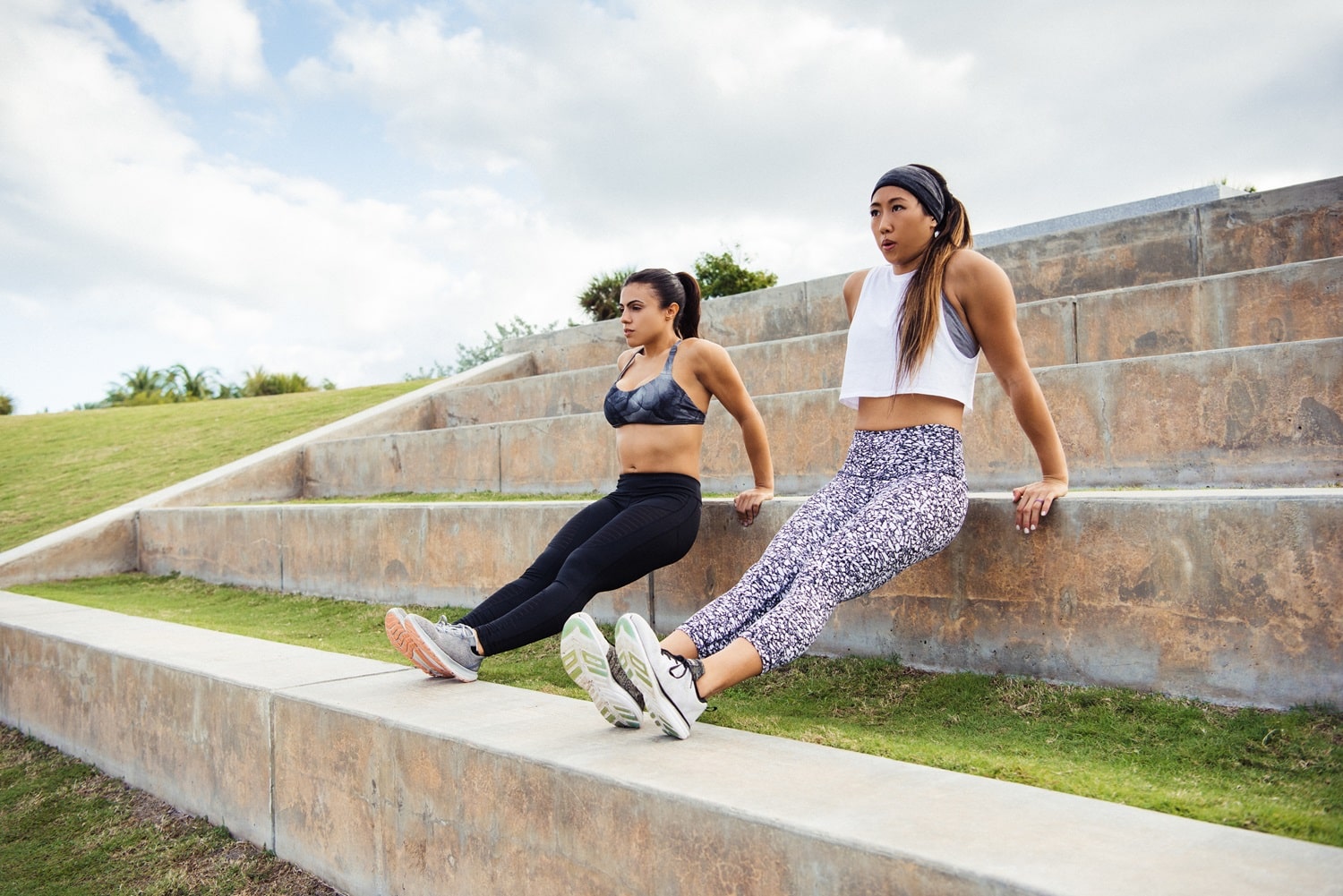 Two young women exercising outdoors, doing push-ups on steps, South Point Park, Miami Beach, Florida, USA Two young women exercising outdoors, doing push-ups on steps, South Point Park, Miami Beach, Florida, USA