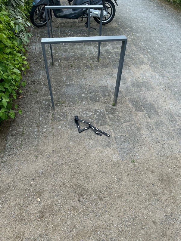 Fahrradschloss am Boden neben einem Fahrradständer