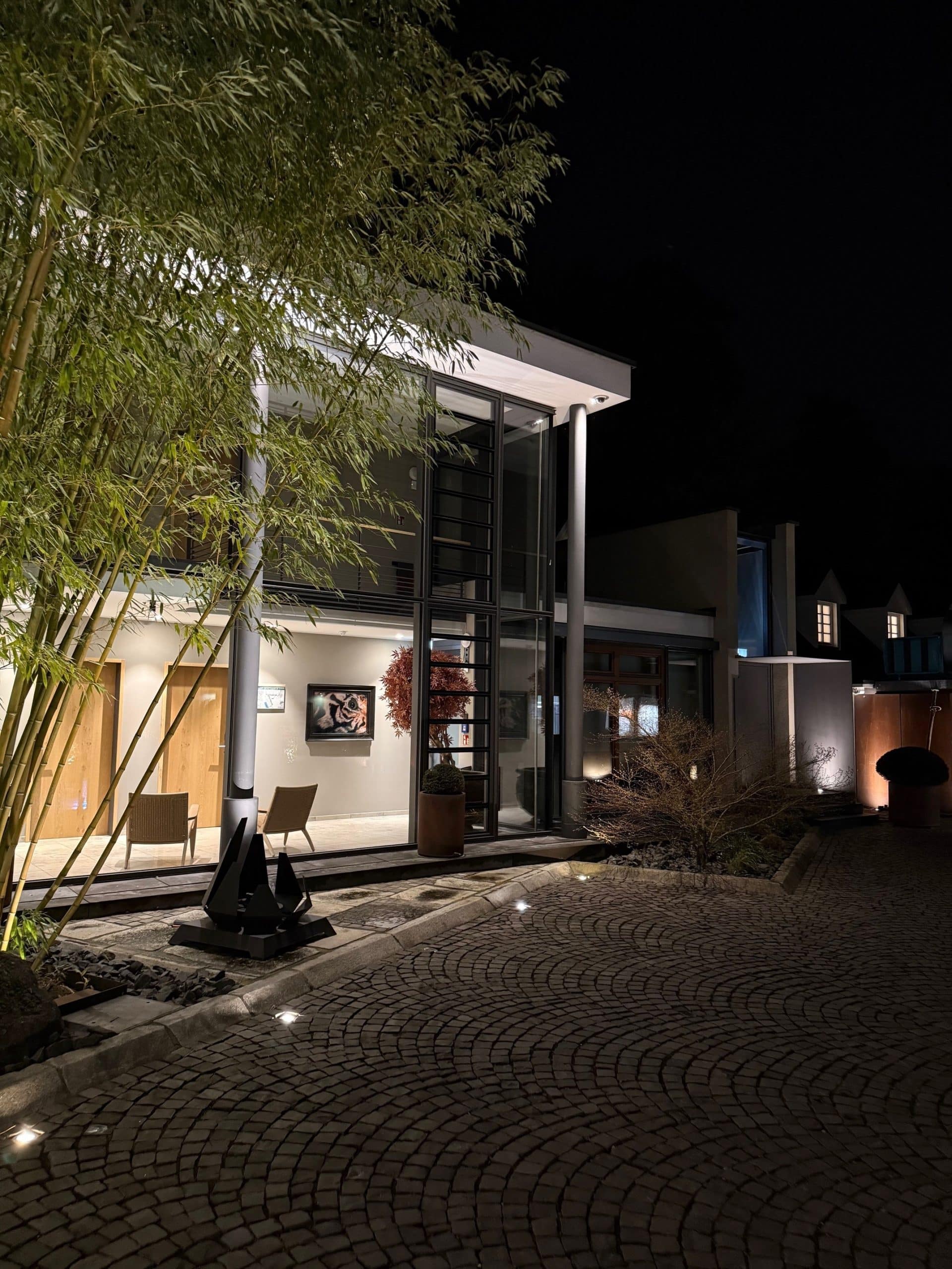 Abendatmosphäre Blick auf den Innenhof und das Hotelgebäude der Diepeschrather Mühle bei Nacht.