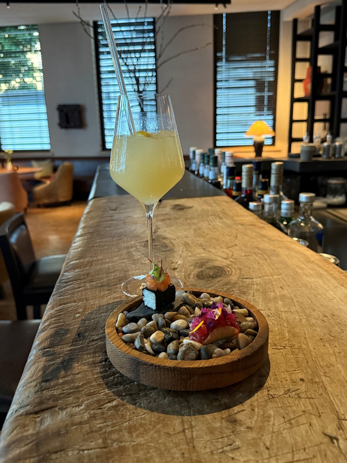 Apero PURS Bar Aperetiv an der Holzbar mit Schälchen mit Nüssen.