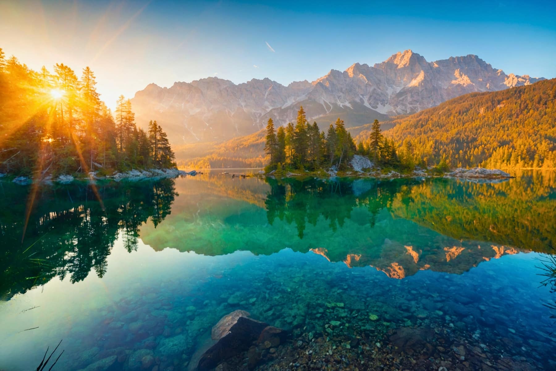 Impressive summer sunrise on Eibsee lake with Zugspitze mountain range. Sunny outdoor scene in German Alps, Bavaria, Germany, Europe. Beauty of nature concept background. Sonnenaufgang über dem Eibsee im Sommer