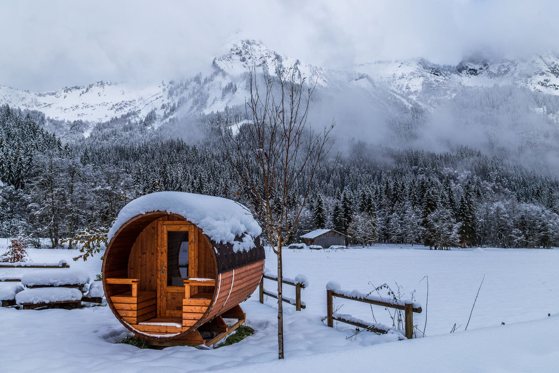 Saunafass im Schnee Fass-Sauna im Schnee mit Bergen im Hintergrund