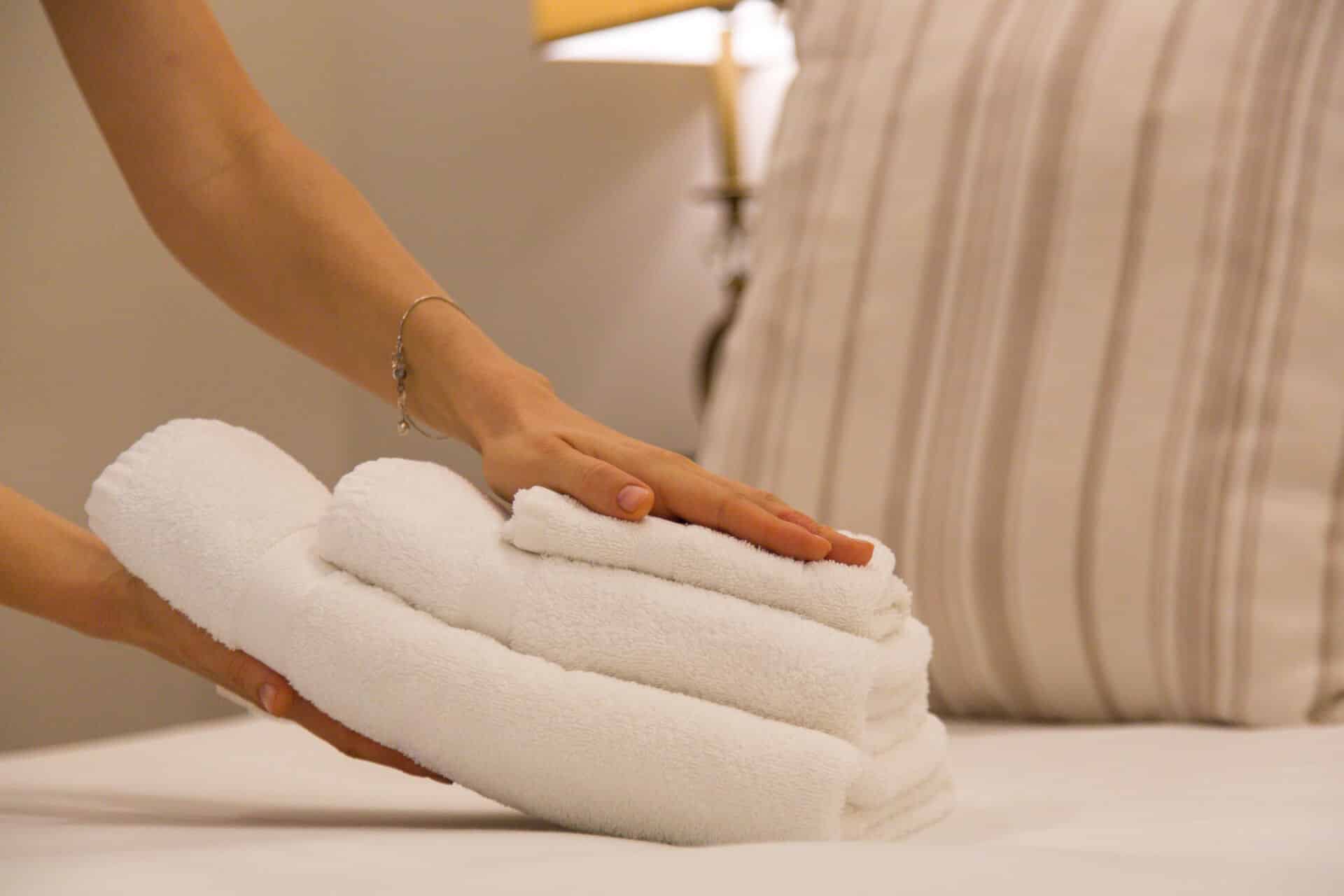 Housekeeping Housekeeping legt Handtücher auf ein Hotelbett